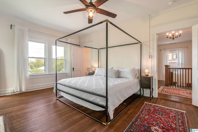 bedroom featuring wood finished floors, multiple windows, a chandelier, and baseboards
