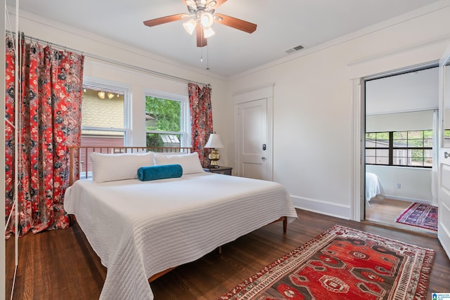 bedroom with multiple windows, wood finished floors, baseboards, ornamental molding, and a ceiling fan