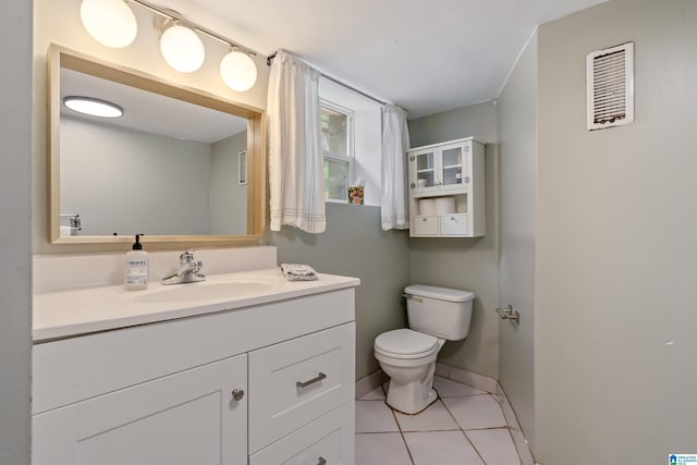 bathroom with toilet, tile patterned flooring, vanity, and baseboards