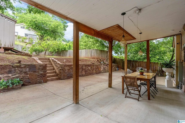 view of patio featuring a fenced backyard, outdoor dining area, and stairway