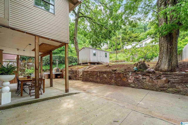 view of patio featuring a storage shed, an outbuilding, and fence