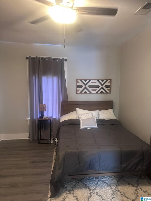 bedroom with a ceiling fan, baseboards, and wood finished floors