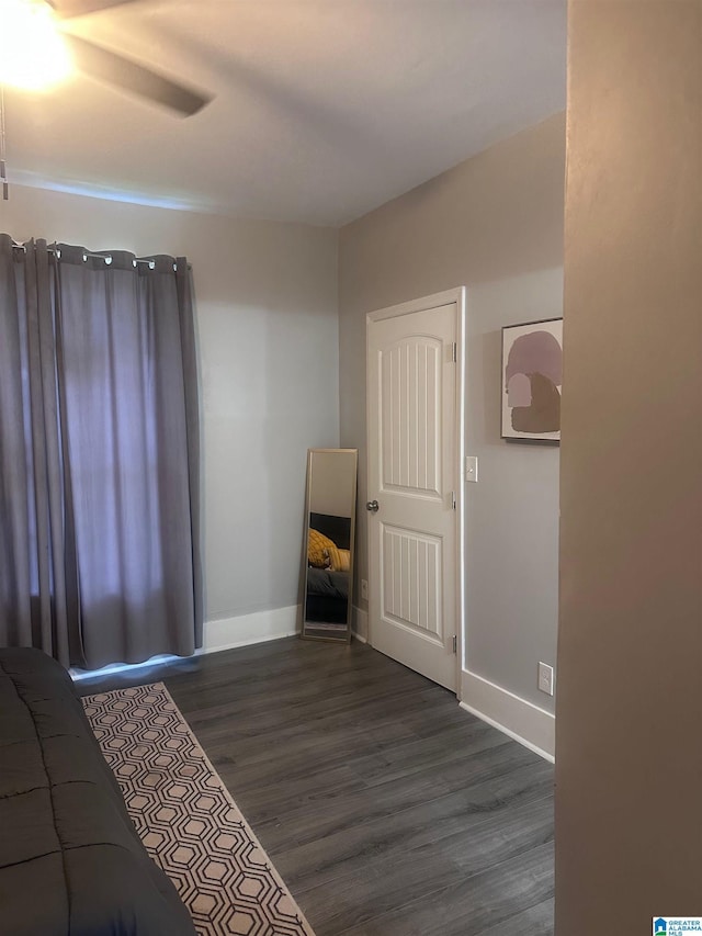 bedroom with dark wood-style flooring, baseboards, and ceiling fan