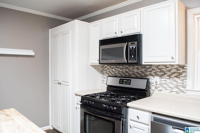 kitchen featuring appliances with stainless steel finishes, decorative backsplash, white cabinets, and ornamental molding