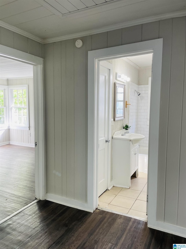 corridor featuring crown molding, wood finished floors, and a sink
