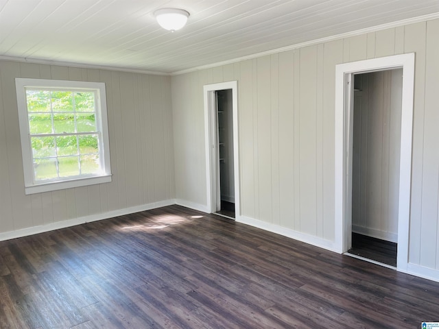 unfurnished bedroom with baseboards, dark wood-style flooring, and ornamental molding