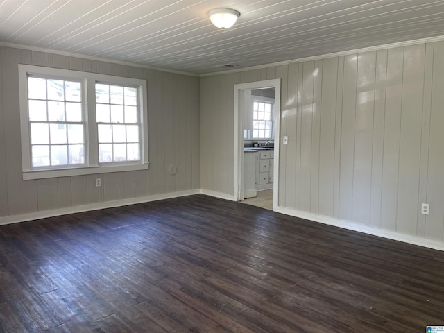spare room featuring wood finished floors, baseboards, and ornamental molding