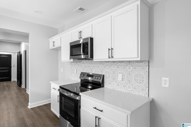 kitchen featuring appliances with stainless steel finishes, dark wood-style floors, light countertops, tasteful backsplash, and white cabinetry