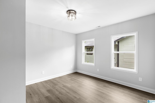 unfurnished room with wood finished floors and baseboards