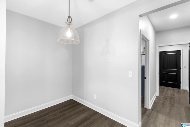 unfurnished dining area with dark wood-style floors and baseboards