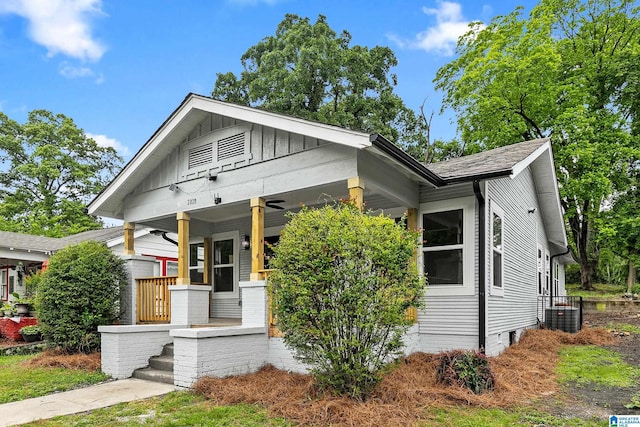 bungalow-style home with covered porch, board and batten siding, and cooling unit