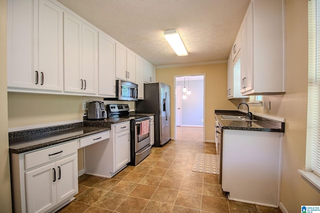 kitchen featuring white cabinetry, appliances with stainless steel finishes, a textured ceiling, and a sink