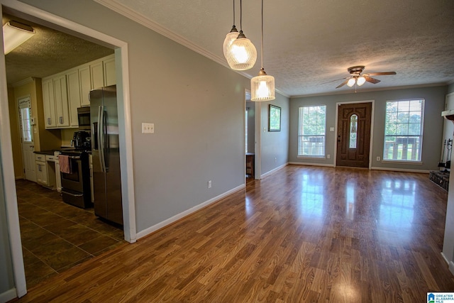 entryway featuring crown molding, a textured ceiling, dark wood-style flooring, baseboards, and ceiling fan