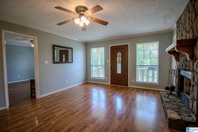 foyer featuring a textured ceiling, a fireplace, wood finished floors, and ceiling fan