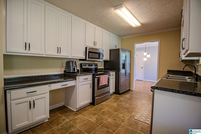 kitchen featuring a sink, stainless steel appliances, ornamental molding, white cabinetry, and dark countertops