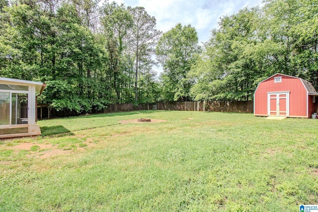 view of yard with an outdoor fire pit, an outbuilding, a fenced backyard, and a storage unit