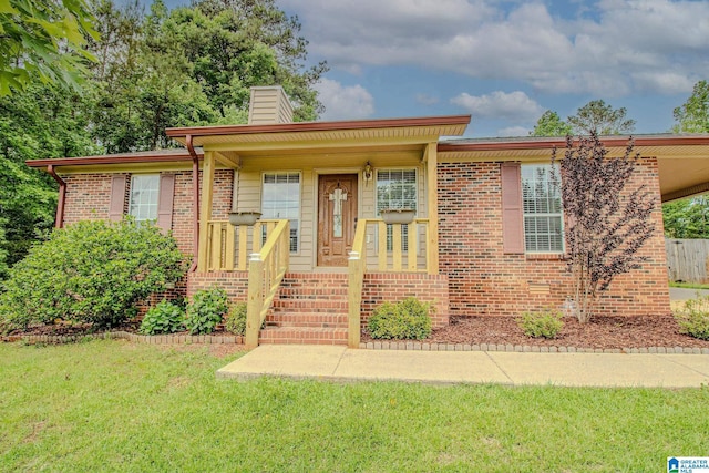 ranch-style home with brick siding, a chimney, a front yard, and a carport