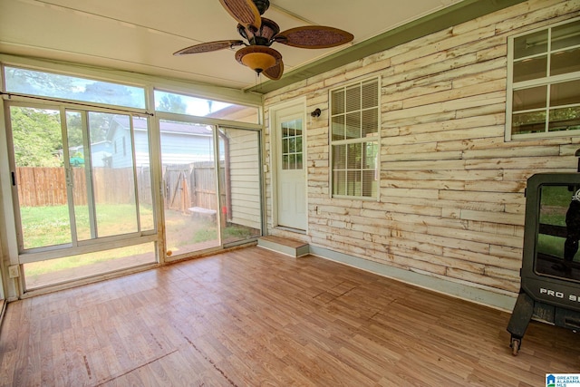 unfurnished sunroom with a ceiling fan and wood finished floors