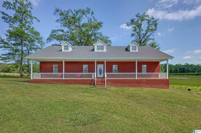 cape cod home featuring covered porch, brick siding, and a front yard