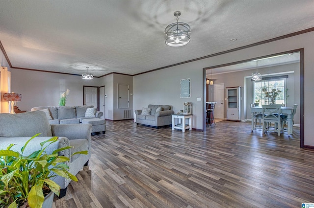 living room featuring an inviting chandelier, dark wood finished floors, baseboards, and a textured ceiling