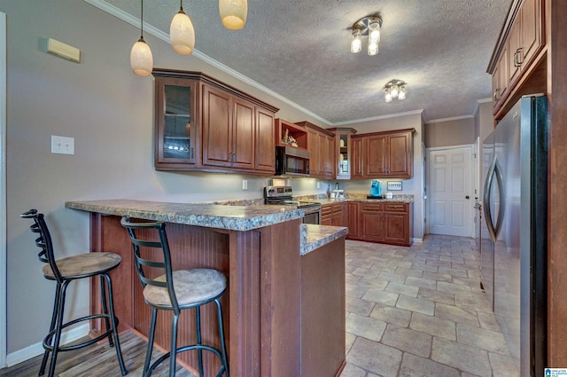 kitchen featuring a peninsula, brown cabinetry, glass insert cabinets, and appliances with stainless steel finishes