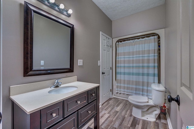 full bath featuring toilet, wood finished floors, a textured ceiling, curtained shower, and vanity