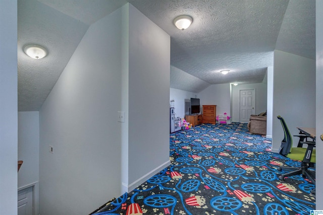 additional living space with a textured ceiling, vaulted ceiling, baseboards, and carpet floors