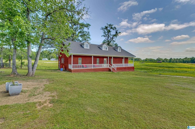 view of front of house featuring covered porch, a front lawn, and brick siding