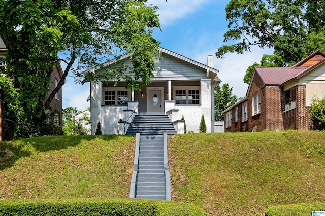 1330 Bush Blvd W, Birmingham, AL 35208 - bungalow-style home featuring stairway, a front yard, brick siding, and a chimney