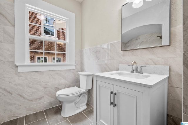 1330 Bush Blvd W, Birmingham, AL 35208 - bathroom with tile walls, toilet, vanity, wainscoting, and tile patterned floors
