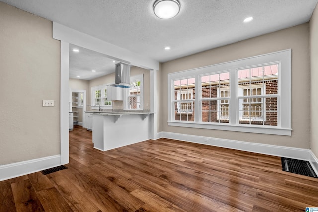 1330 Bush Blvd W, Birmingham, AL 35208 - unfurnished living room featuring wood finished floors, baseboards, a textured ceiling, a sink, and recessed lighting
