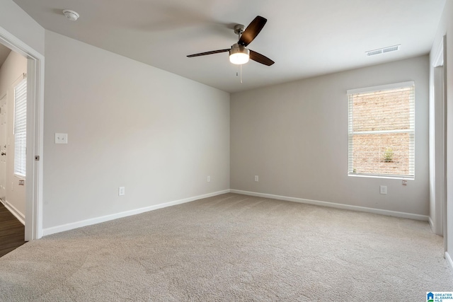 spare room with baseboards, ceiling fan, visible vents, and carpet floors