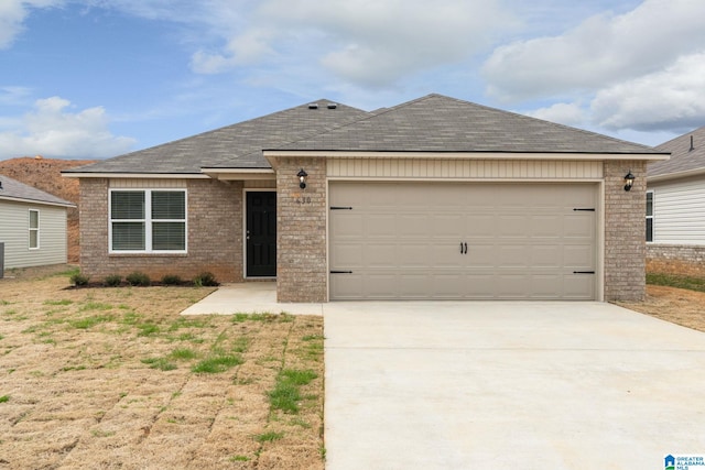 ranch-style house with an attached garage, a shingled roof, brick siding, and driveway