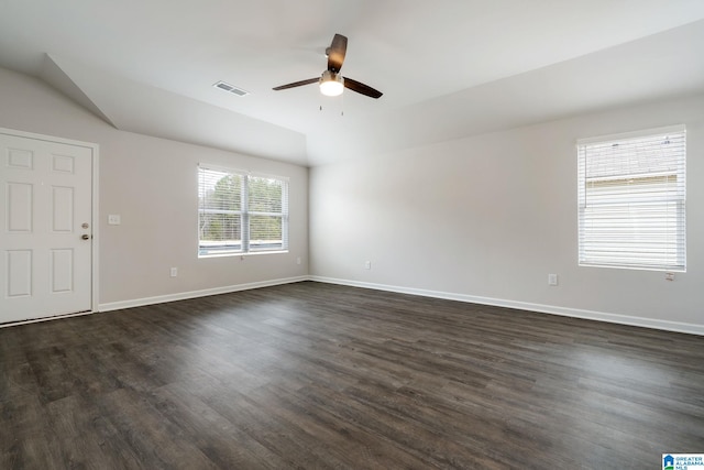 unfurnished room with lofted ceiling, a ceiling fan, visible vents, and dark wood-type flooring