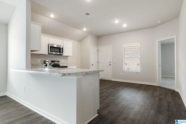 kitchen with a peninsula, stainless steel appliances, white cabinetry, visible vents, and dark wood-style flooring