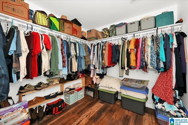 walk in closet with wood finished floors