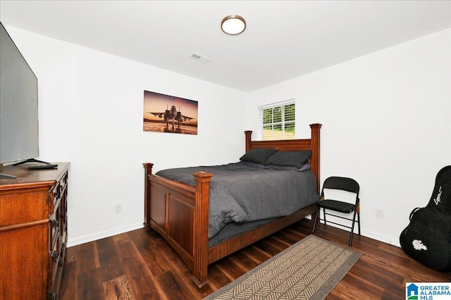bedroom featuring visible vents, dark wood-style flooring, and baseboards
