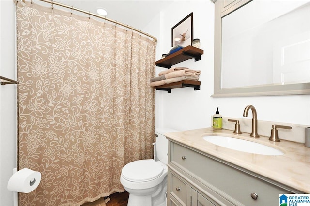 bathroom with toilet, vanity, and curtained shower