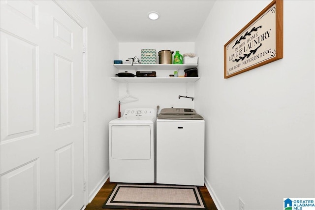 laundry area featuring washer and clothes dryer, laundry area, dark wood-style flooring, and baseboards