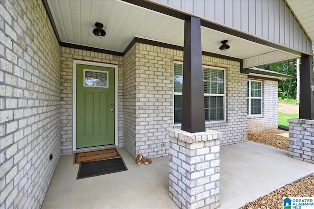 entrance to property with brick siding and covered porch