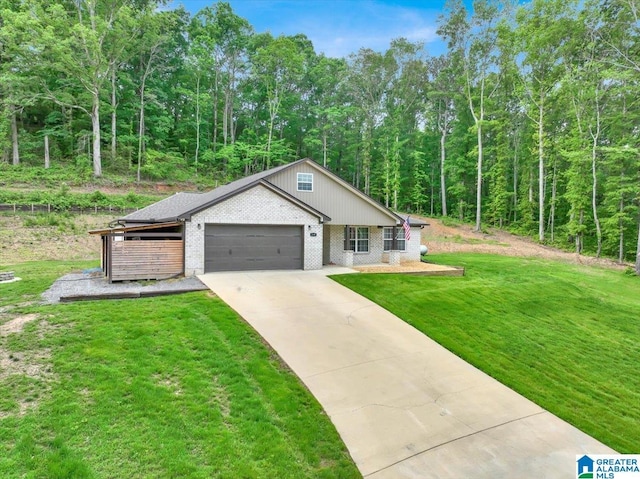 view of front of property with brick siding, a wooded view, concrete driveway, a garage, and a front lawn