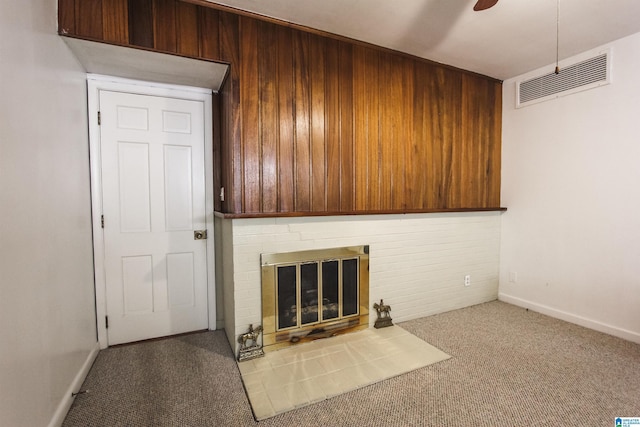 unfurnished living room featuring a ceiling fan, baseboards, carpet flooring, visible vents, and a brick fireplace