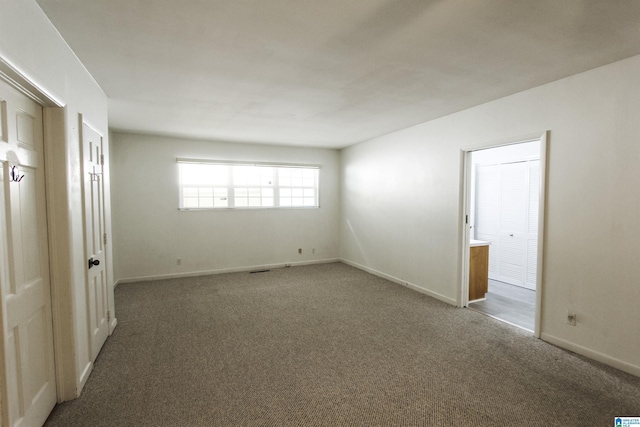 carpeted spare room featuring baseboards