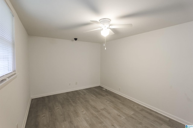 spare room with baseboards, ceiling fan, and wood finished floors