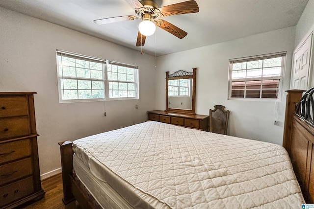 bedroom featuring baseboards, a ceiling fan, and dark wood-style floors