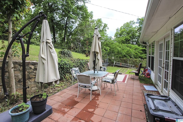 view of patio / terrace featuring french doors, outdoor dining area, and fence
