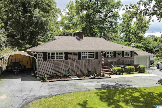 ranch-style home featuring a chimney, a carport, a front lawn, brick siding, and roof with shingles