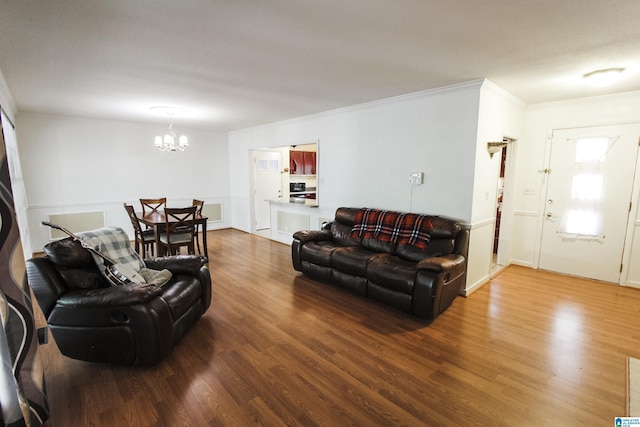 living area featuring an inviting chandelier, wood finished floors, and crown molding