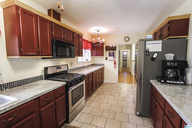 kitchen with an inviting chandelier, dark brown cabinets, stainless steel gas range oven, light tile patterned flooring, and black microwave