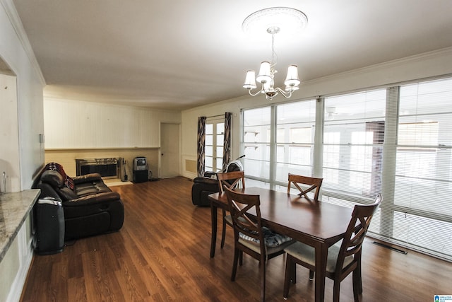 dining area featuring a chandelier, crown molding, and dark wood-style floors